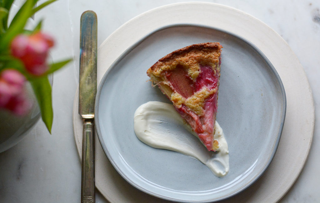 rhubarb cake on a plate with a schmear of sauce