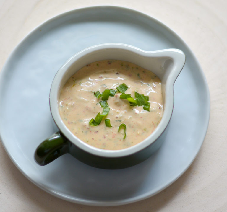 chipotle sauce in a tiny pitcher on a dish