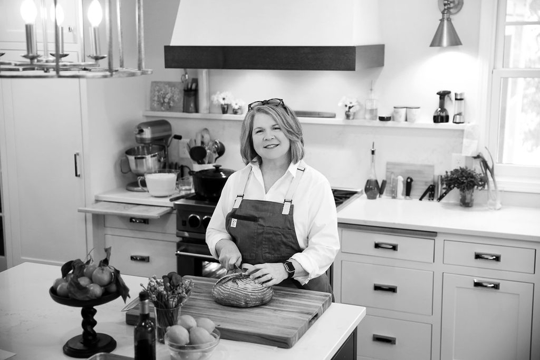 shelagh standing at her kitchen island, slicing sourdough bread