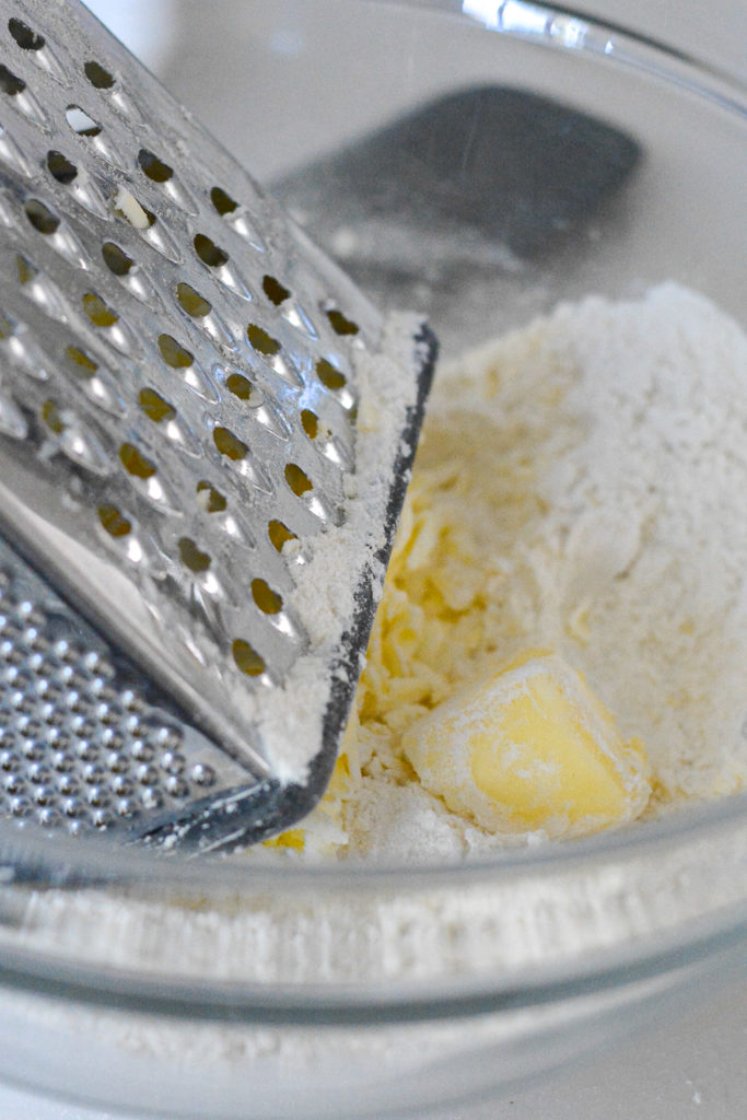grated frozen butter in a bowl of flour. box grater