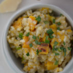 Winter squash risotto in a bowl with parm cheese and tea towel