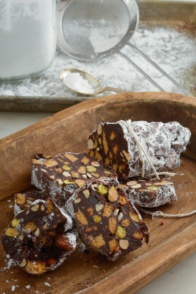 Chocolate Ginger Salami with Hazelnuts with confectioner sugar and sieve in background