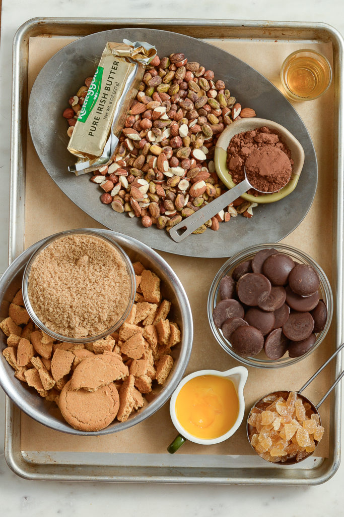 The raw ingredients for making Chocolate Ginger Salami with Hazelnuts: hazelnuts. pistachios, almonds, chocolate, cocoa, butter, brown sugar, gingernut cookies and whiskey