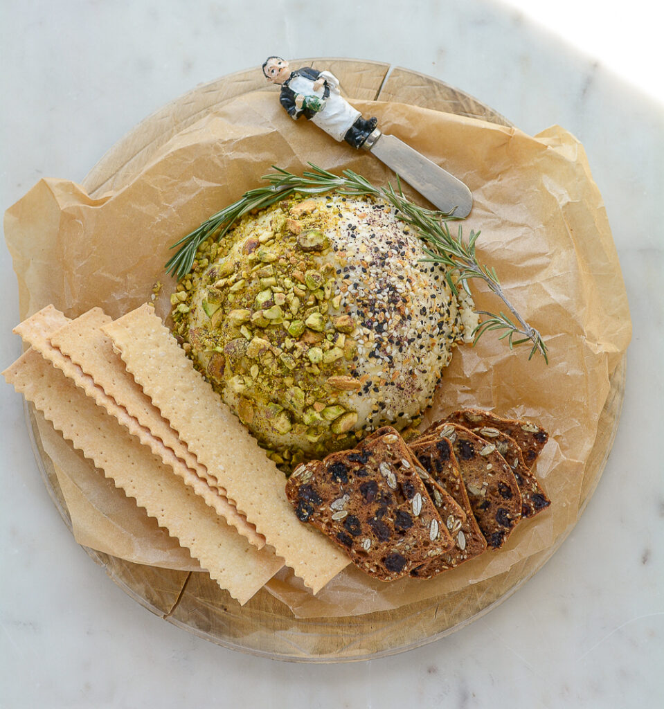 overhead shot of cheeseball on board with crackers