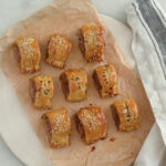 Sausage rolls on a piece of parchment paper and napkin