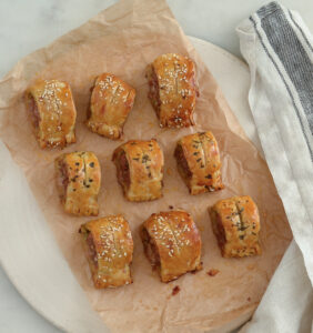 Sausage rolls on a piece of parchment paper and napkin
