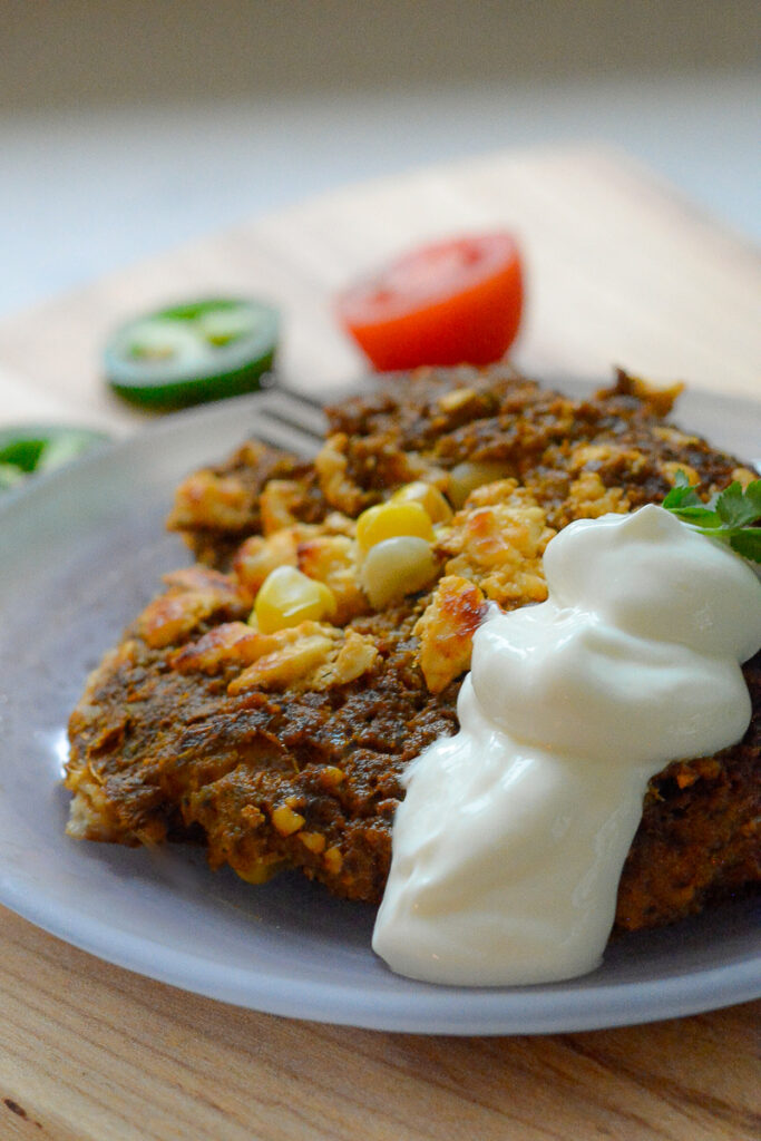 Summer Veg and Bean Enchilada Bake photo on a dish with sour cream