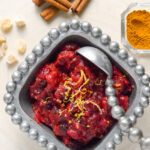 Cranberry Chutney in pewter dish with cinnamon and ginger in background