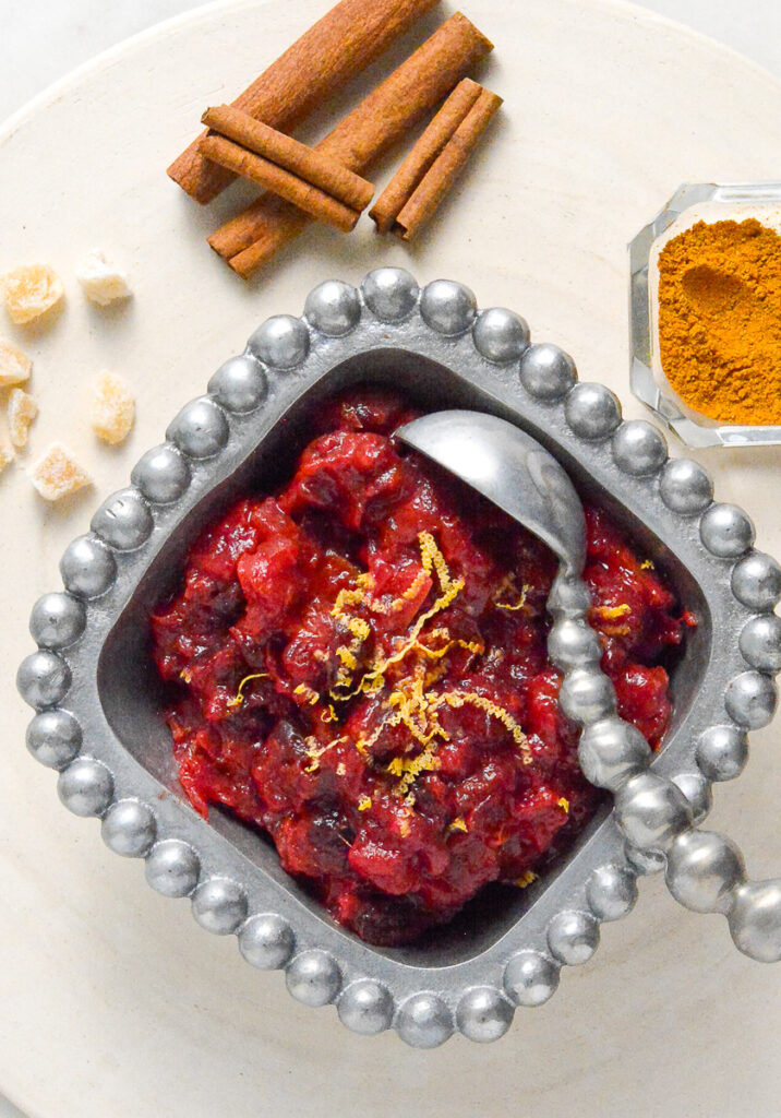 Cranberry Chutney in pewter dish with cinnamon and ginger in background