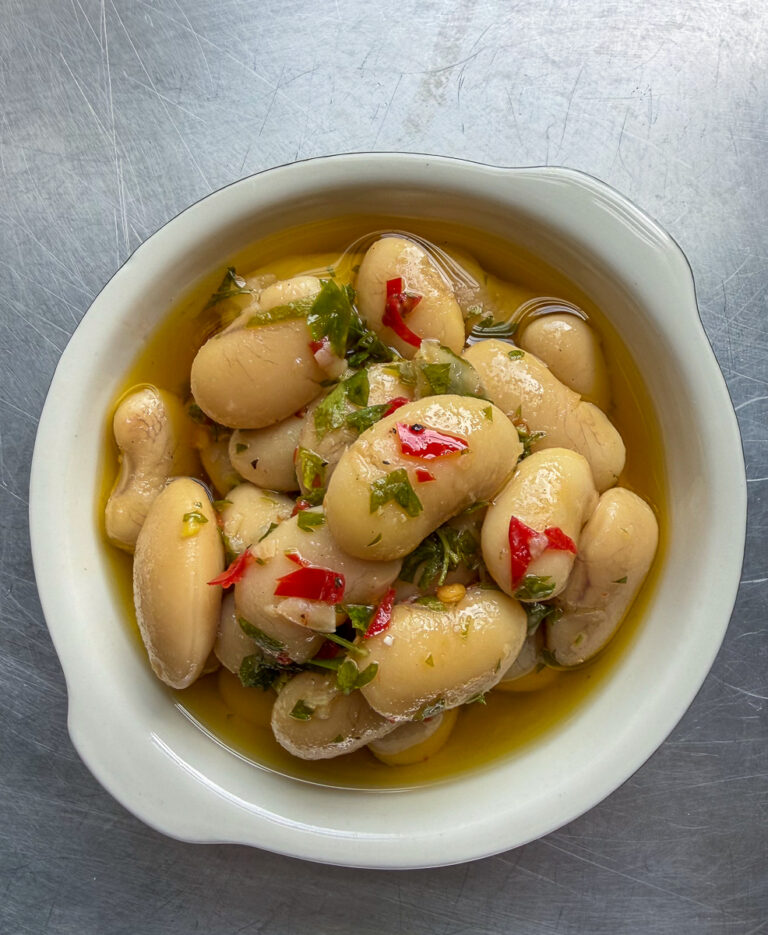 Marinated Corona Beans in a small bowl overhead shot